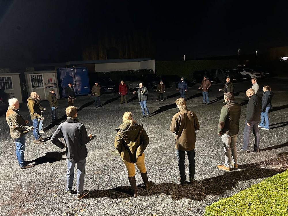 De groep oefent in een kring op de parking bij avond